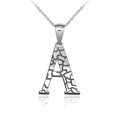 A silver pendant necklace featuring the letter 'A' with a textured, crackled pattern, suspended from a delicate silver chain on a white background with a soft reflection.