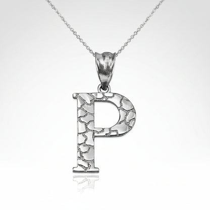 A silver initial pendant necklace featuring the letter 'P' with a textured, crackled metallic finish, suspended from a delicate silver chain on a white background.