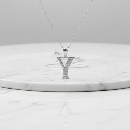 A silver initial pendant necklace featuring the letter 'Y' with a textured, cracked-glass design, suspended from a delicate silver chain on a white background with a soft reflection.