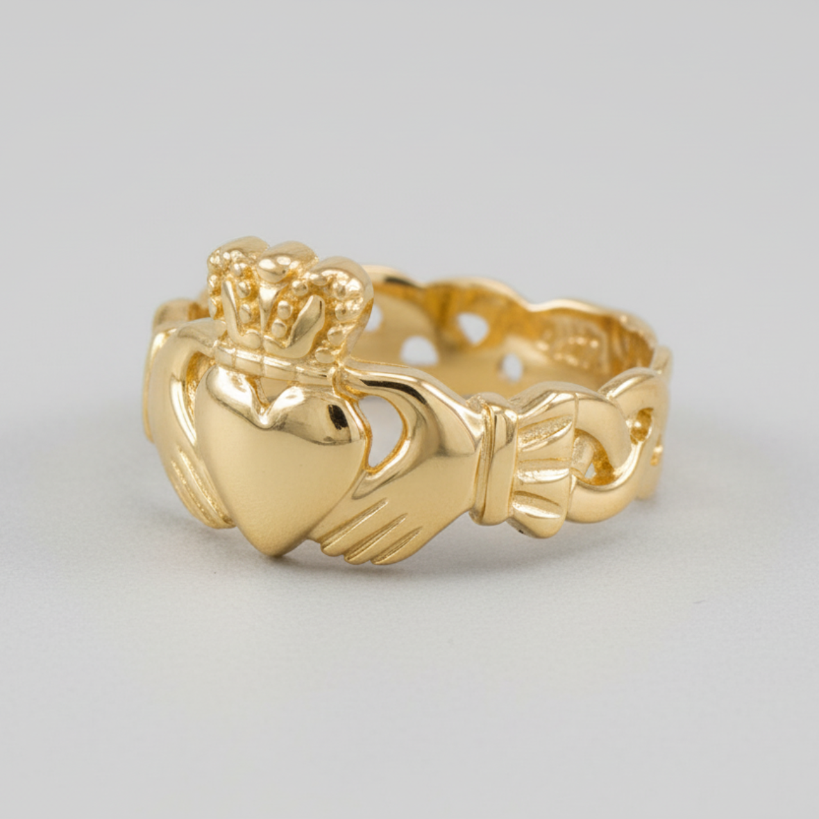 Gold Claddagh ring on a light gray background
