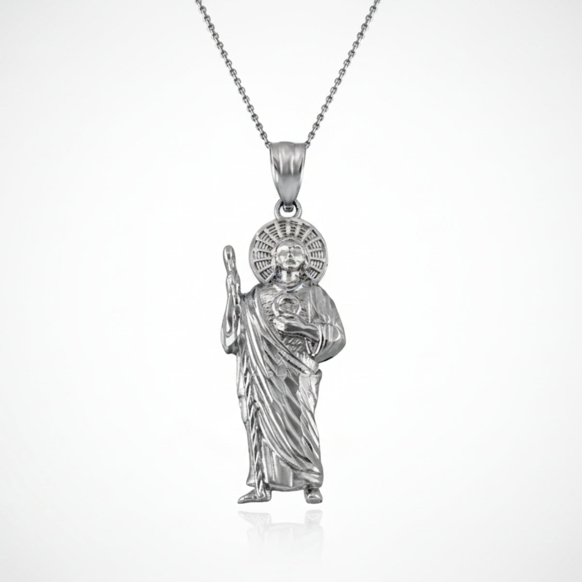 Silver pendant of a religious figure on a white background