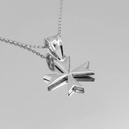 Silver star-shaped pendant on a chain against a gray background