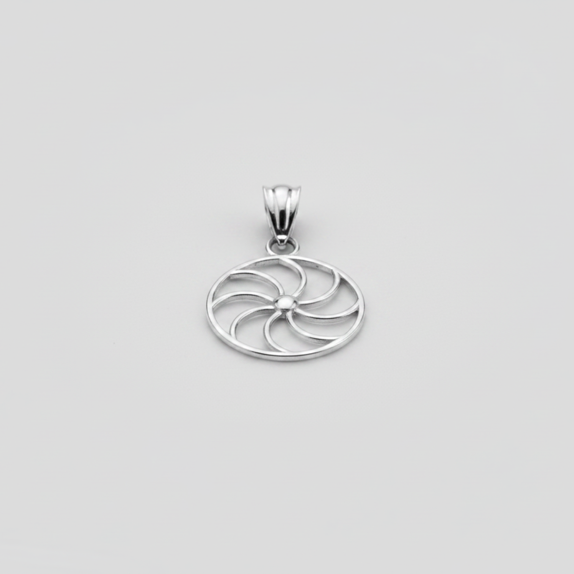 Silver pendant with a circular design on a white background