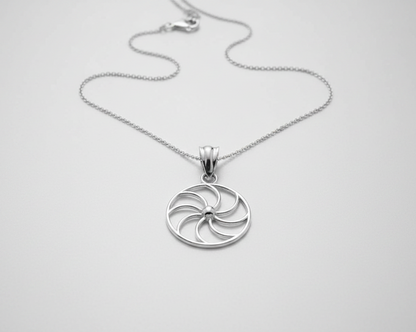 Silver circular pendant necklace on a white background