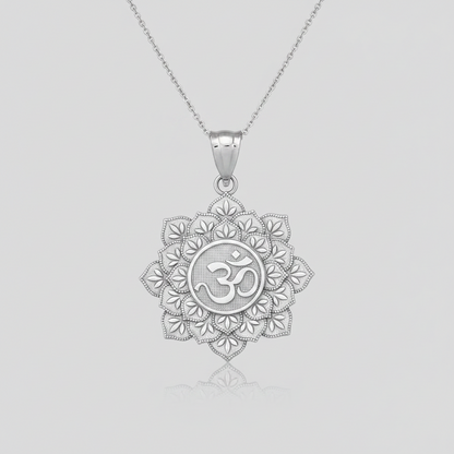 A silver pendant necklace featuring a detailed lotus flower design with an Om symbol in the center, suspended from a delicate silver chain against a light gray background.