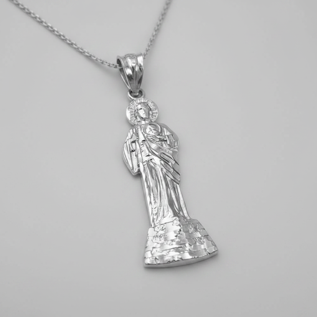 A sterling silver pendant necklace featuring a detailed figure of the Virgin Mary holding the infant Jesus, suspended from a matching silver chain against a neutral gray background.