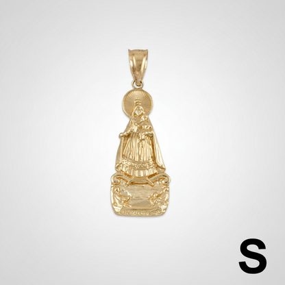Gold pendant with religious figure on a white background with measurement scale.