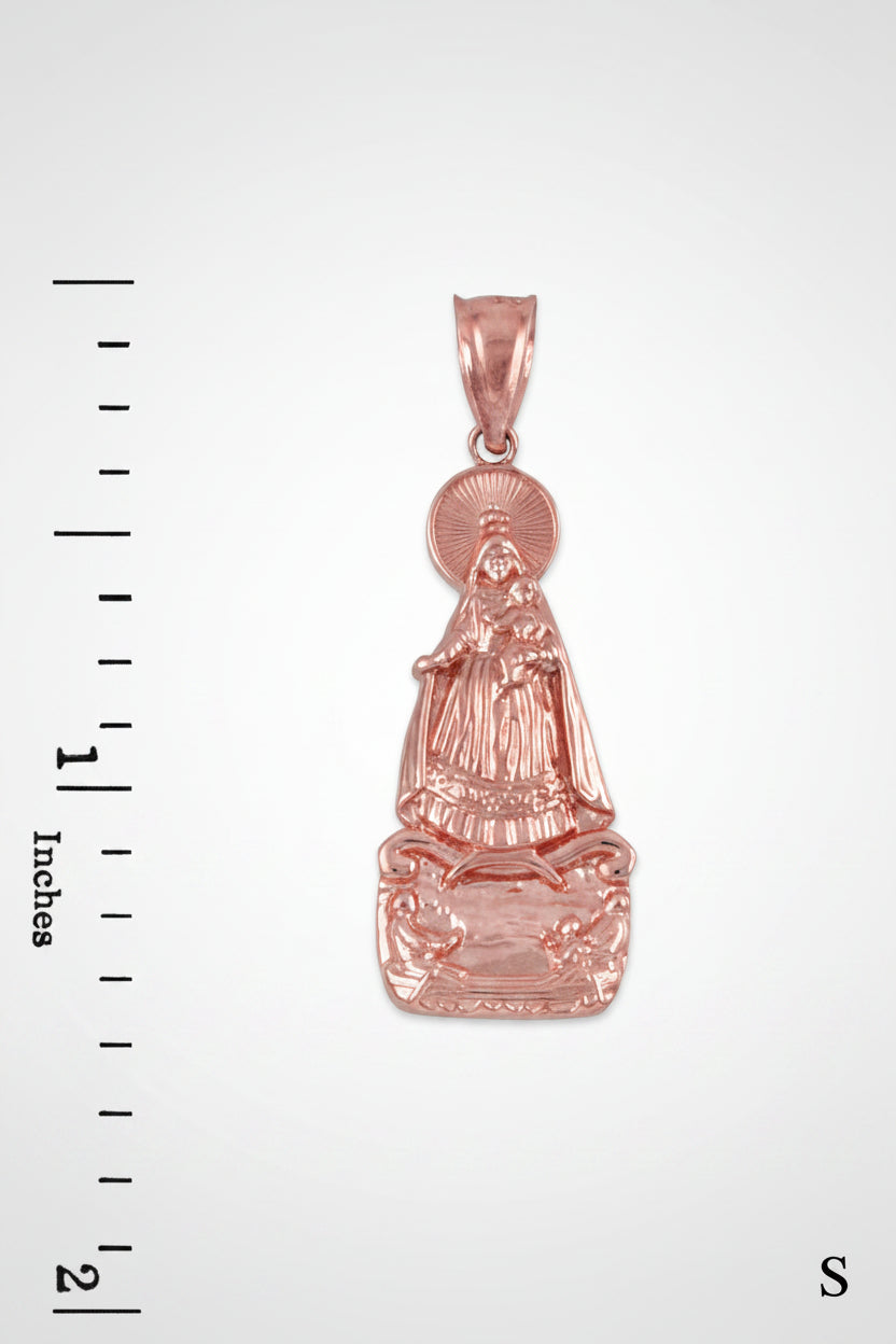 Gold pendant with religious figure on a white background with measurement scale.