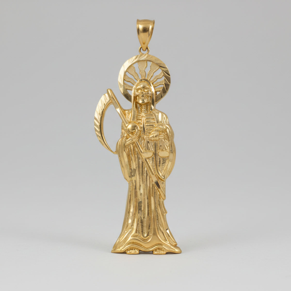 Gold pendant of a Santa Muerte religious figure with a halo on a white background