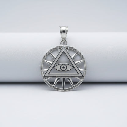 Silver pendant with eye design on a white background