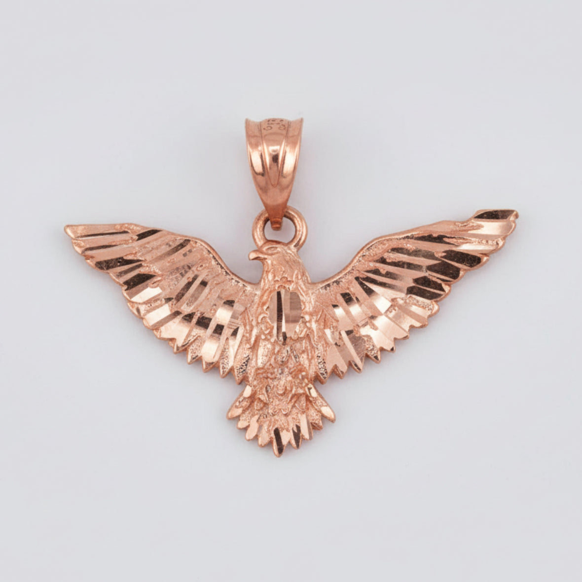 Rose gold eagle pendant on a white background