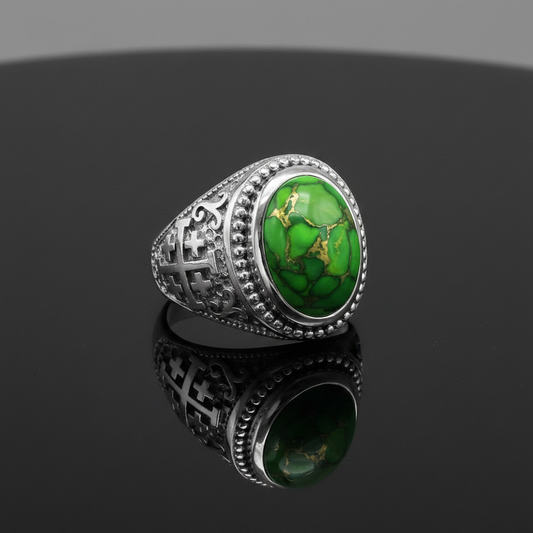 A silver-toned men's ring featuring a large oval green turquoise cabochon with natural gold veining, set on a dark reflective surface.