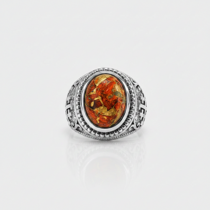 A silver-toned ring featuring an oval amber cabochon with visible golden and orange inclusions, set against a clean white background with a soft reflection below.