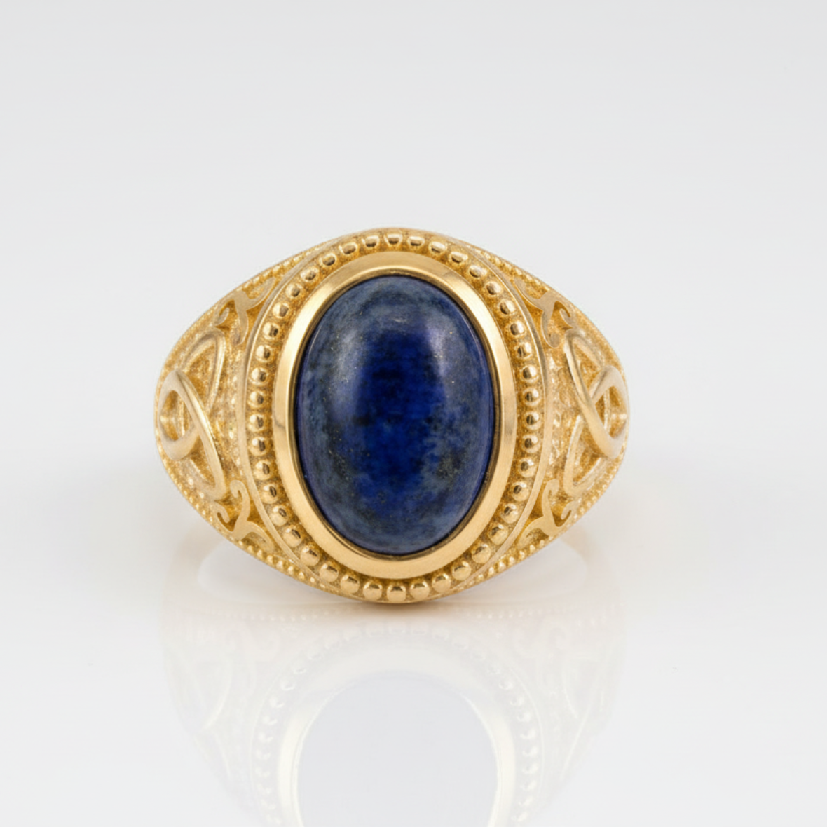 Gold ring with a blue stone on a white background
