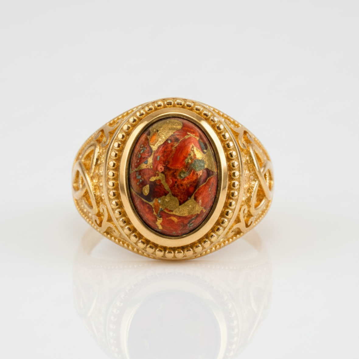 Gold ring with a red stone on a white background