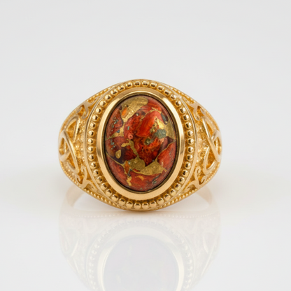Gold ring with a red stone on a white background