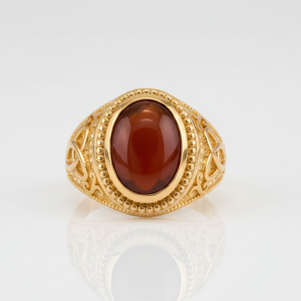 Gold ring with a red stone on a white background