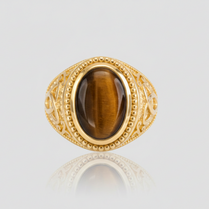 Gold ring with a brown gemstone on a light gray background