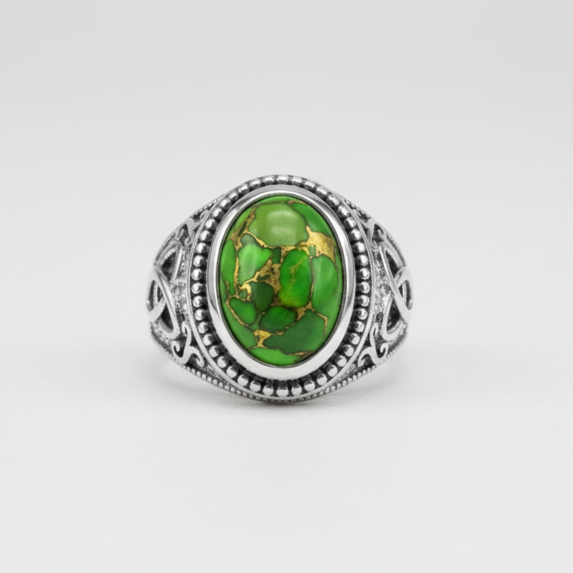 Silver ring with a green gemstone on a white background