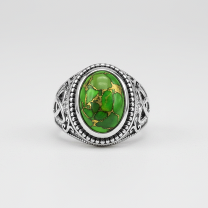 Silver ring with a green gemstone on a white background