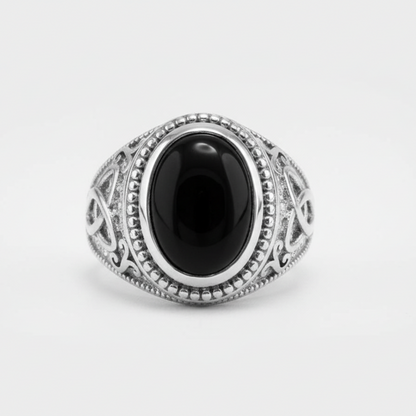 Silver ring with a black stone on a white background