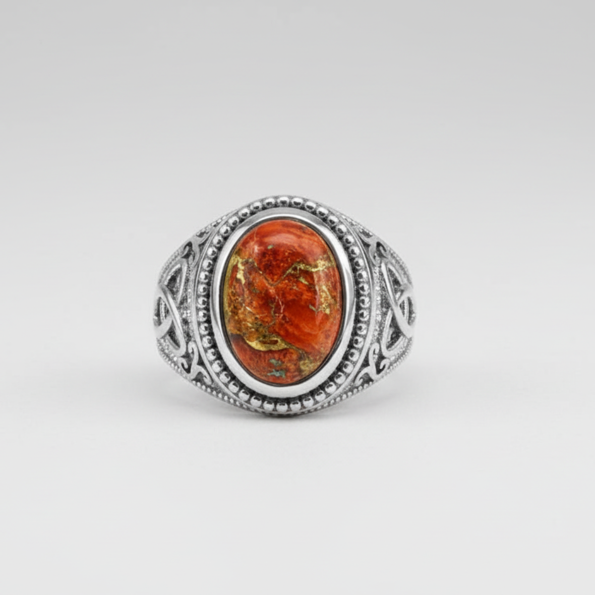 Silver ring with an orange stone on a white background