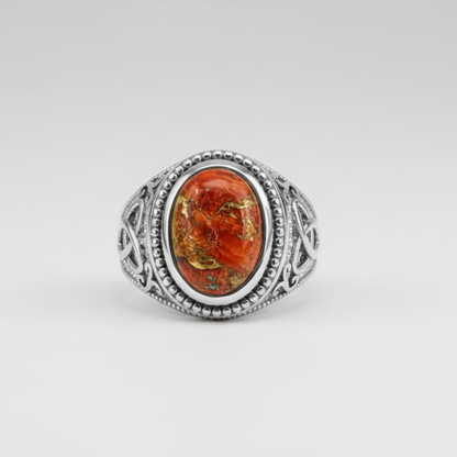 Silver ring with an orange stone on a white background