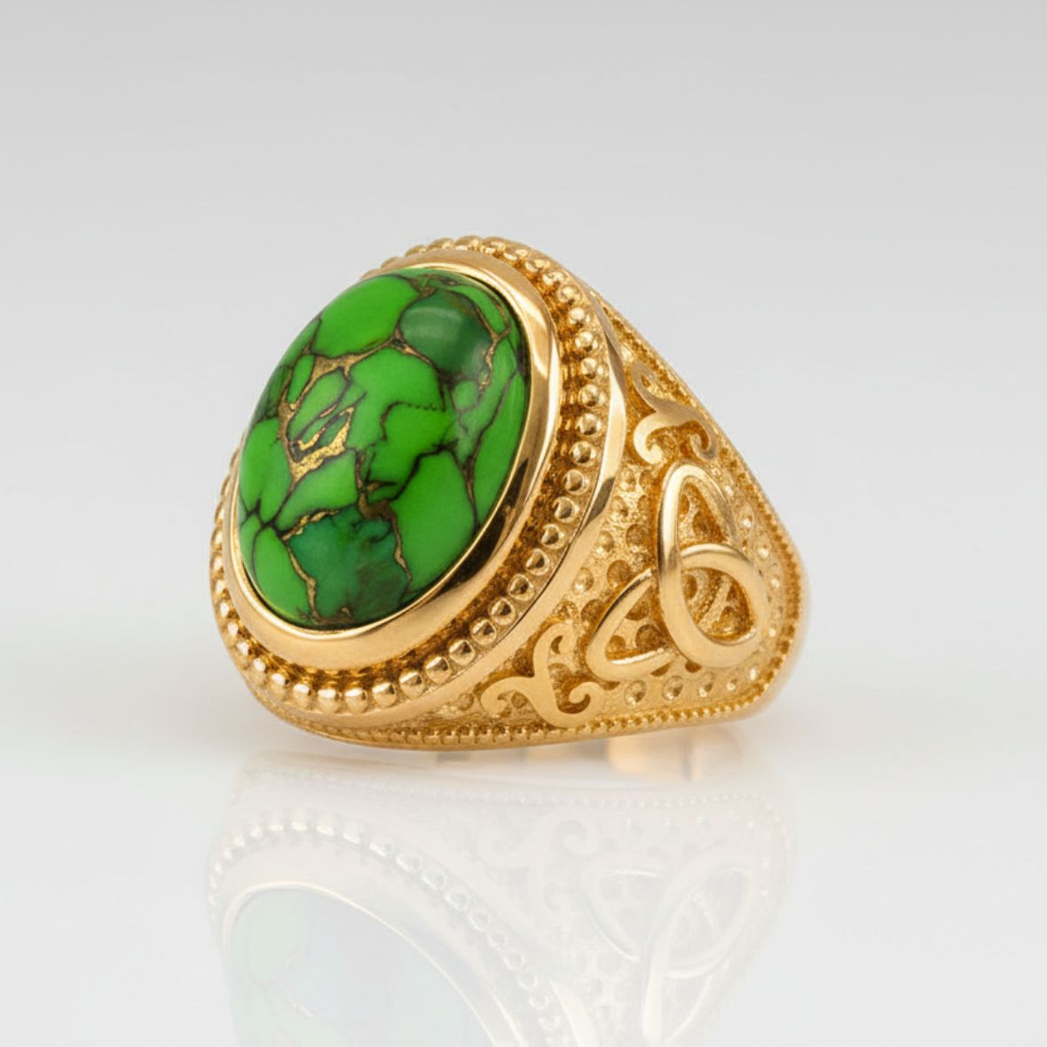 Gold ring with a green stone on a white background