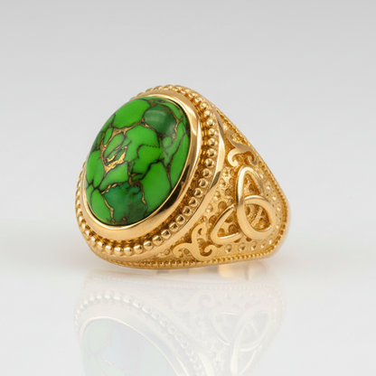 Gold ring with a green stone on a white background