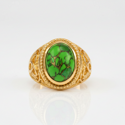 Gold ring with a green stone on a white background