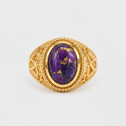 Gold ring with a purple gemstone on a white background