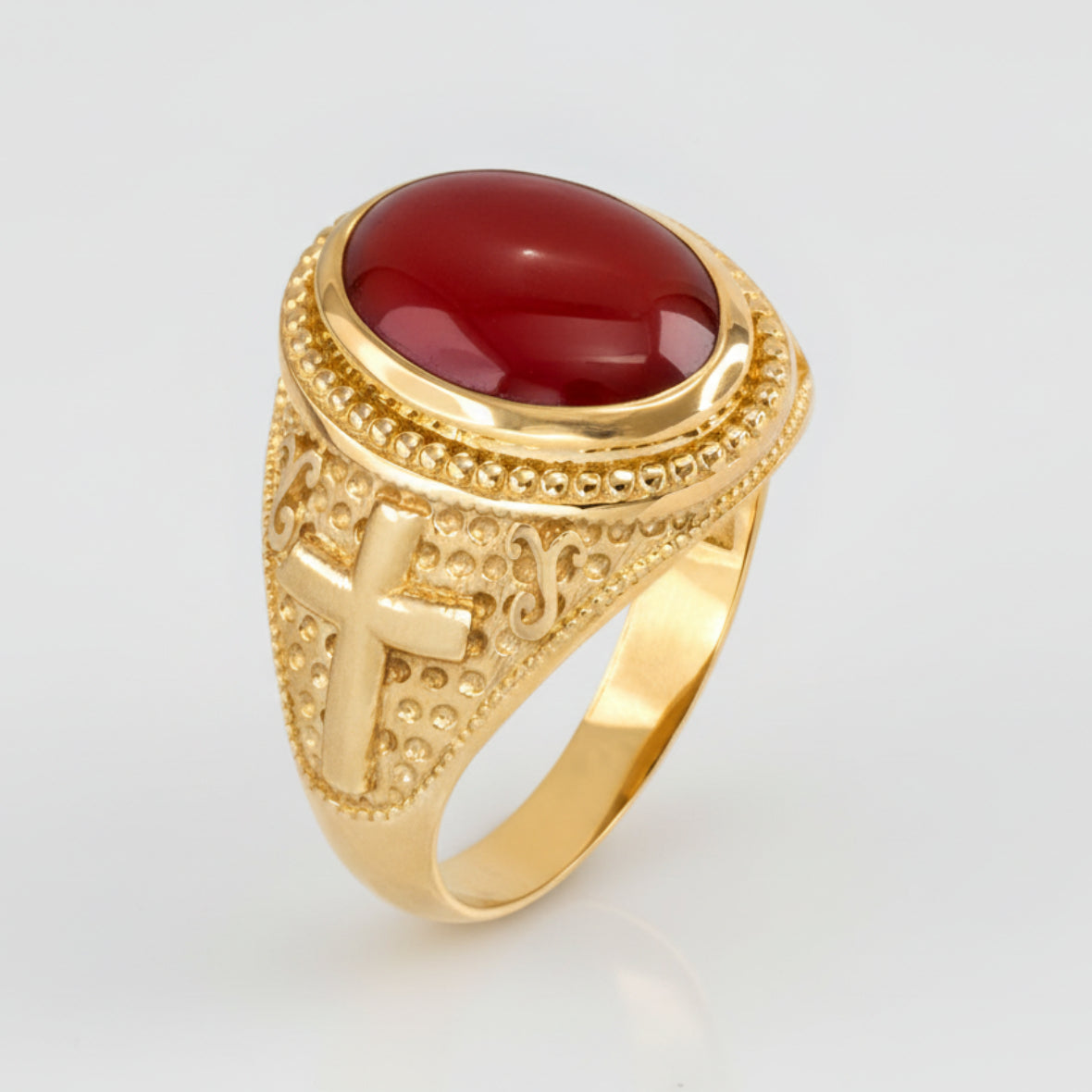 Gold ring with a red stone on a white background