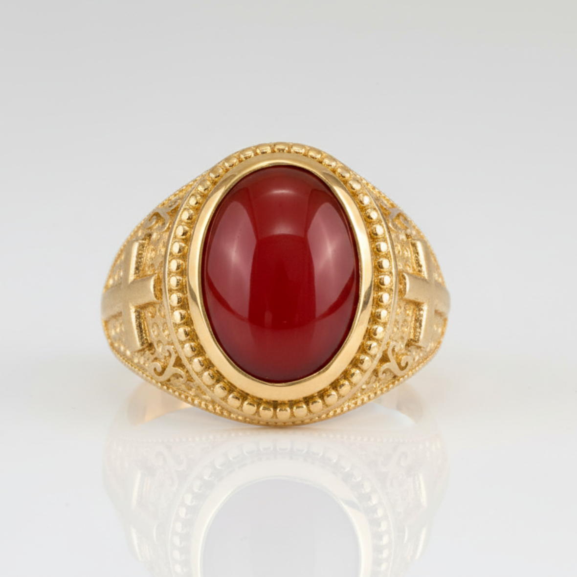 Gold ring with a red stone on a white background