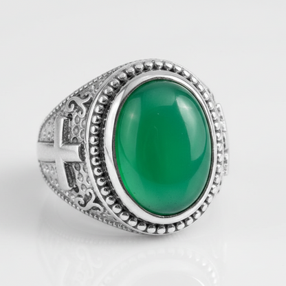 Silver ring with a green stone on a white background