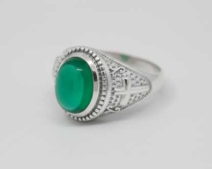Silver ring with a green stone on a light gray background