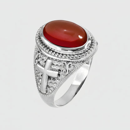 Silver ring with a red stone on a white background