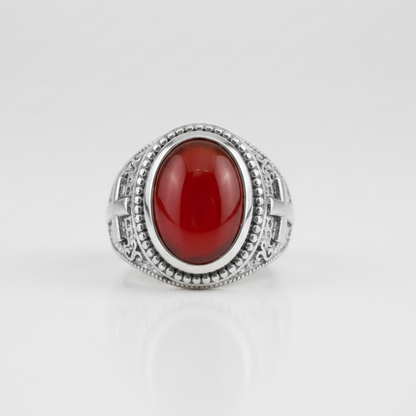 Silver ring with a red stone on a white background
