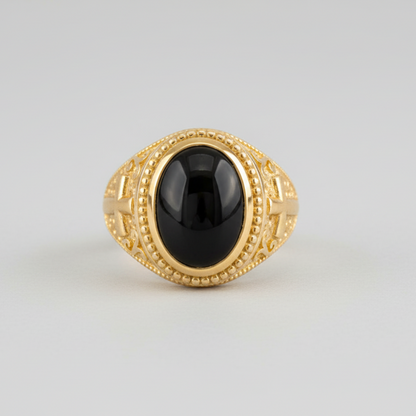 Gold ring with a black gemstone on a light gray background