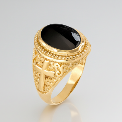 Gold ring with black stone on a gray background