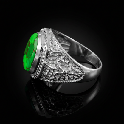 A silver-toned men's signet ring with a large, vibrant green oval cabochon gemstone and intricate floral engraving on the band, displayed on a reflective black surface.