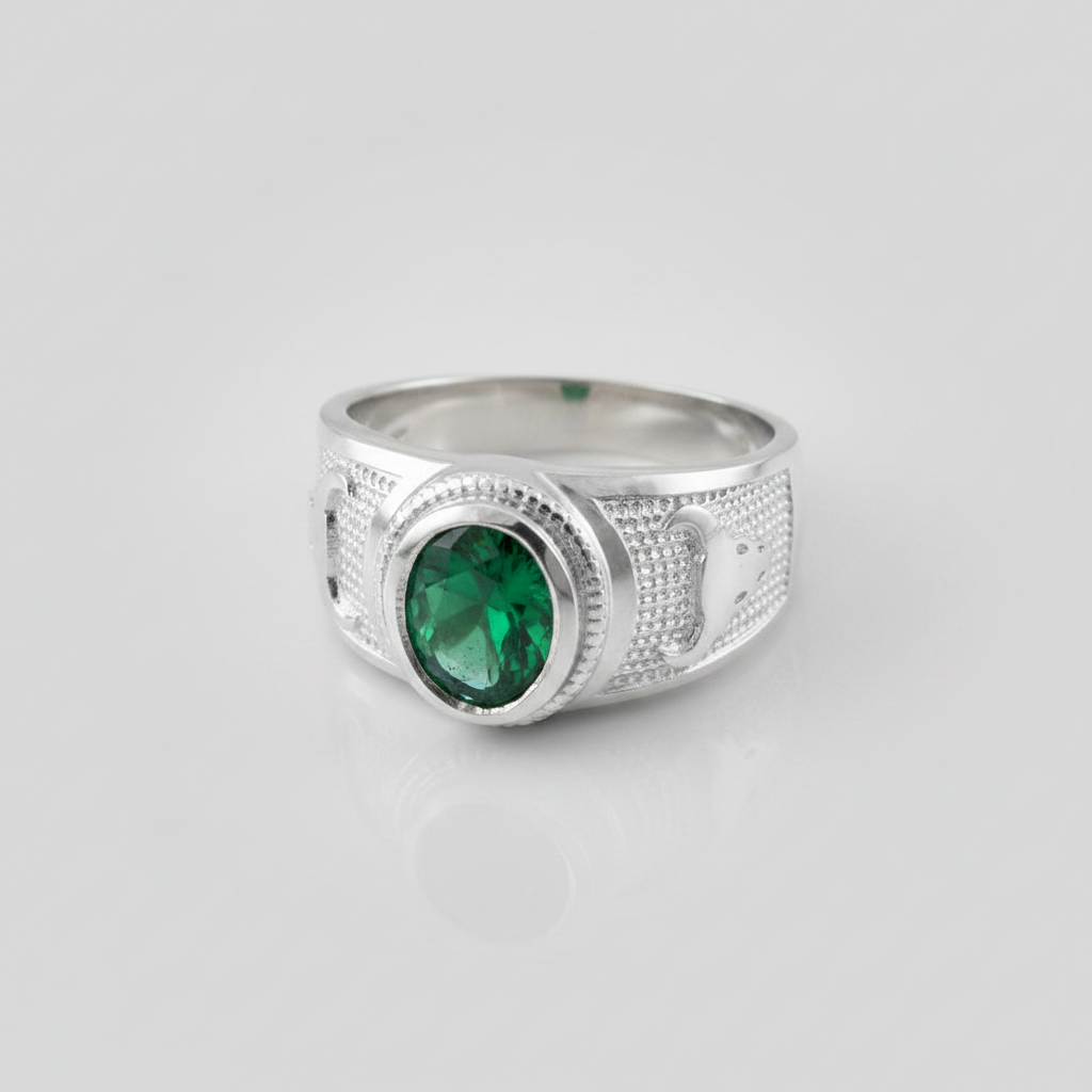 Silver ring with a green gemstone on a light gray background