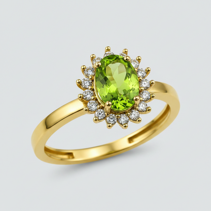 A yellow gold ring featuring an oval-cut green peridot gemstone surrounded by a halo of small round clear stones, set against a plain white background.