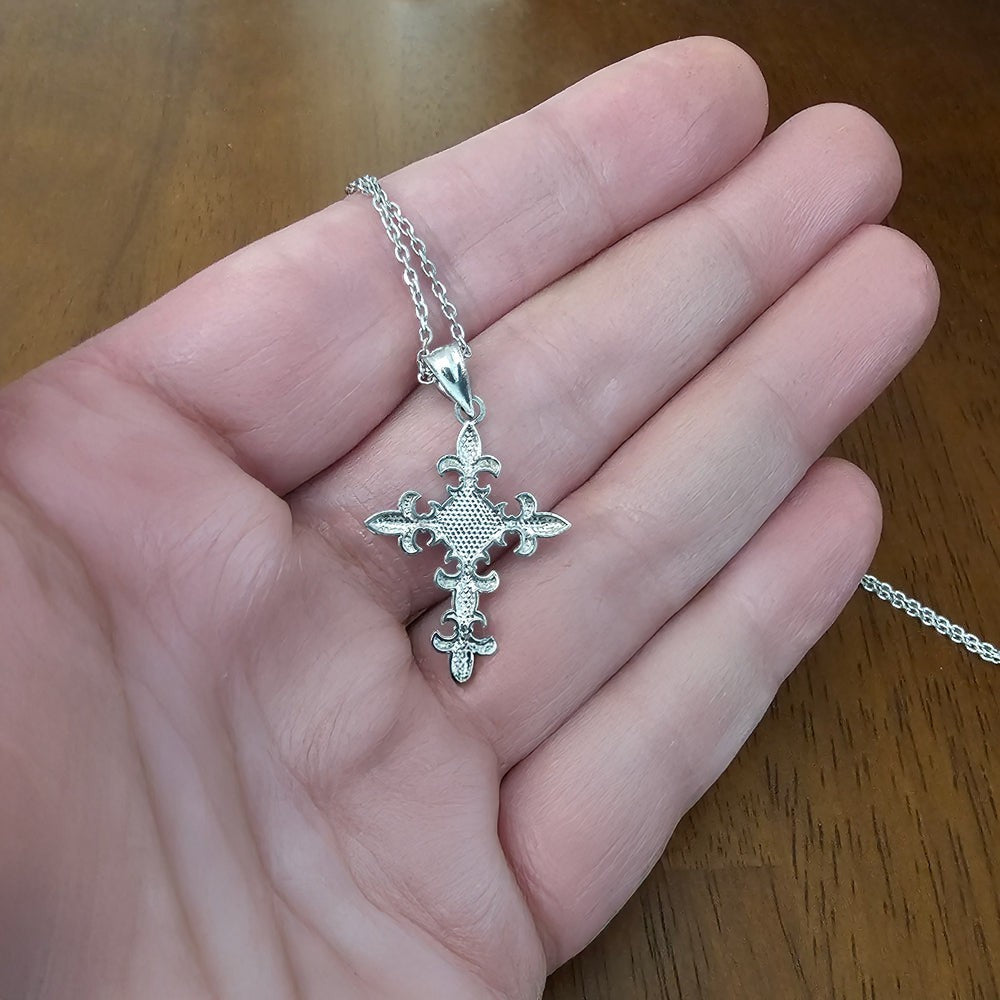 Karma Blingz white gold fleur de lis cross pendant necklace with polished finish and textured center detail.